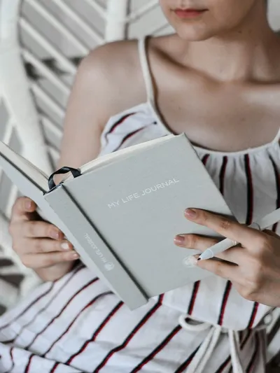 Woman reading book while sitting - Photo by Prophsee Journals on Unsplash