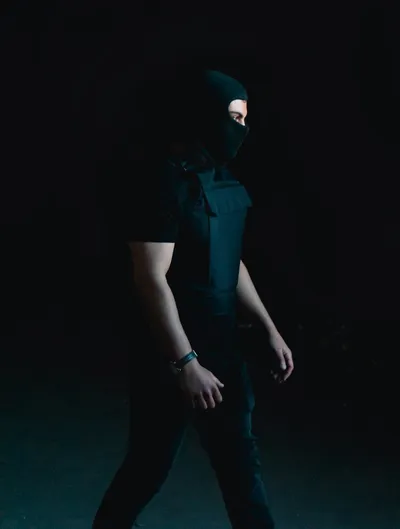 Man in black hoodie walking in darkness - Photo by Erkan Kirdar on Unsplash