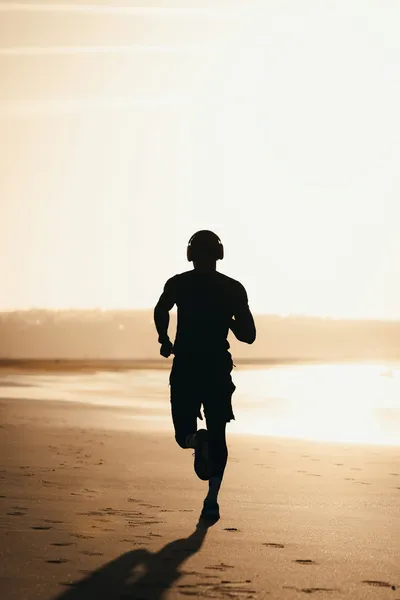 Man running on beach at sunset - Photo by Sara Ruffoni on Unsplash