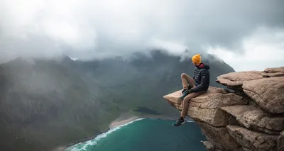 Person overlooking water from a rock — Photo by Benoît Deschasaux on Unsplash