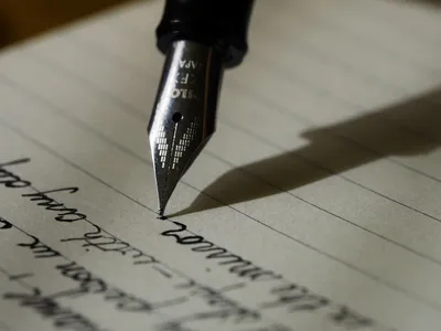 Fountain pen writing on paper — Photo by Aaron Burden on Unsplash