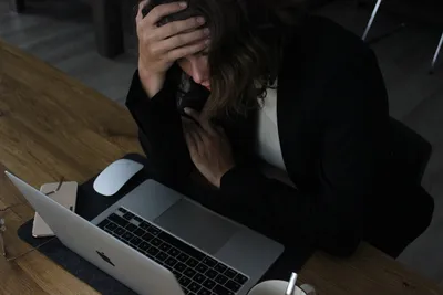 Stressed woman at desk overwhelmed by work — Photo by Elisa Ventur on Unsplash