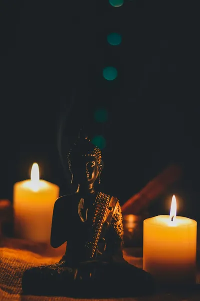 Photo by Rajat Verma on Unsplash A Buddha statue beside candles, representing stillness, meditation, and the unmoving mind