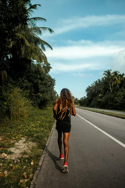 Woman walking on the road during daytime, representing the power of morning exercise and movement. Photo by Ismail Mohamed - SoviLe on Unsplash